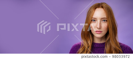 Headshot of sensual and attractive tender redhead female with freckles and pure skin looking at camera focused and sincere with slightly opened mouth, posing against purple background Headshot of sensual and attractive tender redhead female with freckles and pure skin looking at camera focused and sincere with slightly opened mouth, posing against purple background 98033972