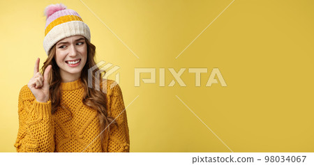 Displeased attractive picky woman describing small object show tiny thing cringing dislike disappointment look upset fingers, describing little salary new job, standing yellow background awkward 98034067