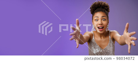 Amused elegant woman looking desire extend arms widen eyes impressed gasping extend arms towards camera hug give embrace cannot resist temptetion standing blue background Amused elegant woman looking desire extend arms widen eyes impressed gasping extend arms towards camera hug give embrace cannot resist temptetion standing blue background 98034072