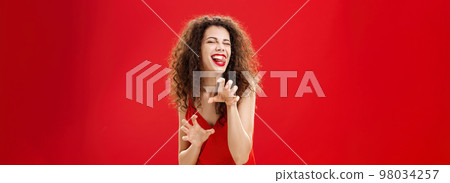Roar gonna eat you sweetie. Sensual and seductive playful european woman with curly hairstyle forplaying in bedroom with lover in red evening dress making animal paws sticking out tongue and winking Roar gonna eat you sweetie. Sensual and seductive playful european woman with curly hairstyle forplaying in bedroom with lover in red evening dress making animal paws sticking out tongue and winking 98034257