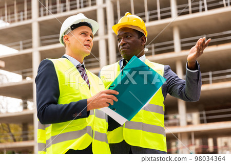 Two architect, civil engineer or building contractor colleagues on construction site 98034364