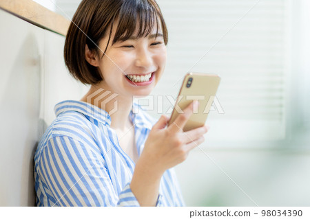 一個操作智能手機的年輕女子 98034390