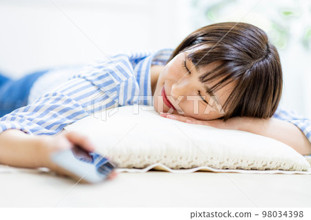 A woman who falls asleep while holding a smartphone A woman who falls asleep while holding a smartphone 98034398