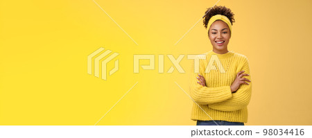Serious powerful good-looking smiling african-american female femenist blogger cross hands chest confident pose grinning delighted enjoying watching working process, standing yellow background 98034416