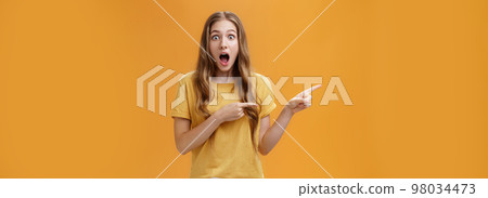 Just look at this prices. Portrait of shocked and amazed speechless cute beautiful woman with natural hairstyle and little scar on arm dropping jaw from amazement pointing left amused and excited 98034473