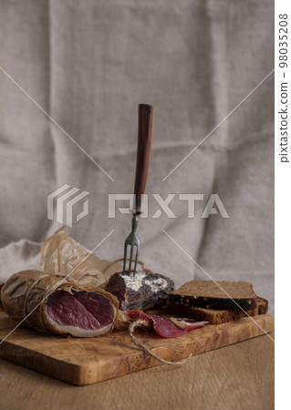 Close-up piece of jamon on fork, light appetizer, homemade food, selective focus 98035208