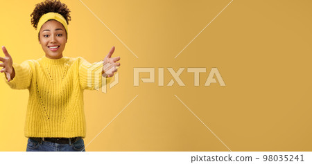 Come closer let me hug you. Touched lovely glad african-american young pretty woman extend arms wanna hold charming cute baby arms asking cuddle embrace friendly, posing yellow background 98035241