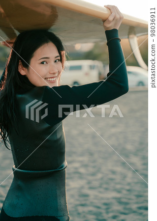 A young woman who enjoys surfing 98036911
