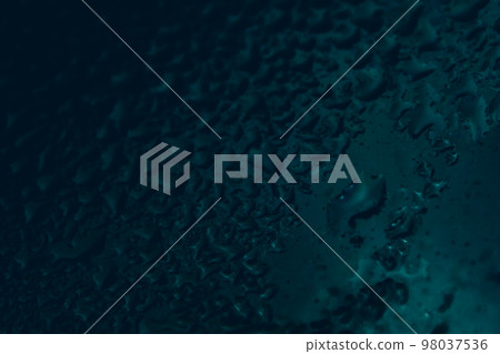 Texture of a glass surface with blue-black water droplets on a dark background Texture of a glass surface with blue-black water droplets on a dark background 98037536