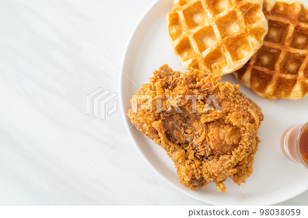 fried chicken waffle with honey or maple syrup fried chicken waffle with honey or maple syrup 98038059