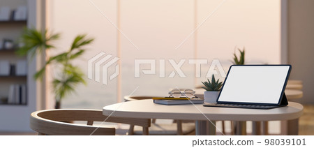 close-up image, Digital tablet mockup and decor plant on table in beautiful coffee shop 98039101