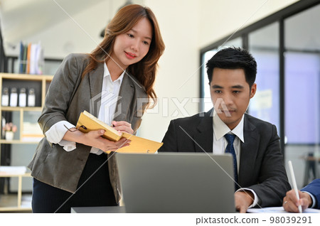 Attractive young Asian female secretary or assistant working with her male boss 98039291