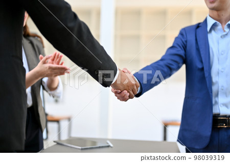 Two successful businessmen shaking hands after meeting. dealing business. cropped image Two successful businessmen shaking hands after meeting. dealing business. cropped image 98039319
