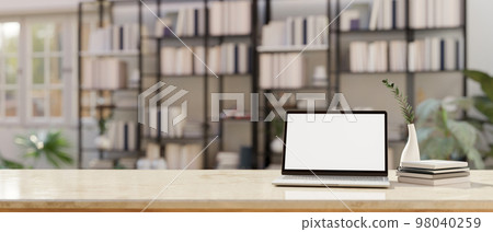 Workspace with laptop mockup and copy space over blurred background of bookshelves Workspace with laptop mockup and copy space over blurred background of bookshelves 98040259