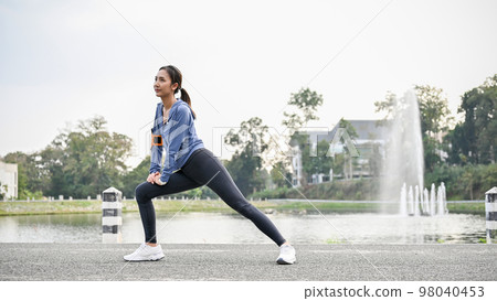 Healthy Asian woman in sportswear stretching her legs, getting ready to run at the city park. Healthy Asian woman in sportswear stretching her legs, getting ready to run at the city park. 98040453