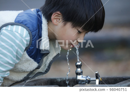 A boy drinking water 98040751