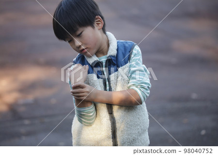 boy holding his wrist boy holding his wrist 98040752