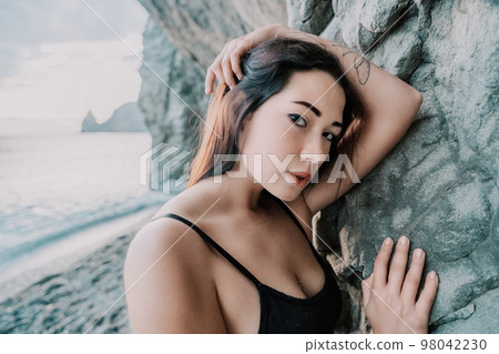 Portrait of cheerful female climber resting on a volcanic basalt 98042230
