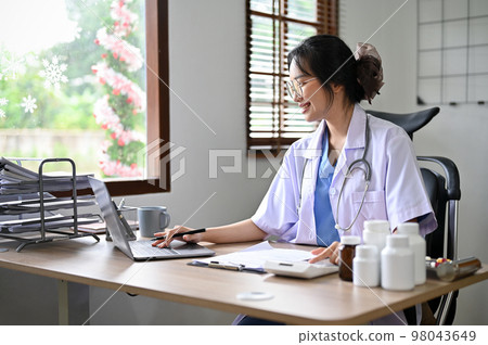 Attractive Asian female doctor using calculator and laptop, estimating surgery cost for her patient Attractive Asian female doctor using calculator and laptop, estimating surgery cost for her patient 98043649
