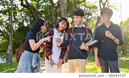 Group of happy Asian college students enjoy talking and walking in the campus's park together. 98044197