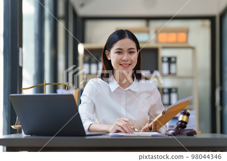 Lawyer working at office. Asian Lawyer doing with contract or document in office. Law, legal services, advice, Justice and real estate concept Lawyer working at office. Asian Lawyer doing with contract or document in office. Law, legal services, advice, Justice and real estate concept 98044346