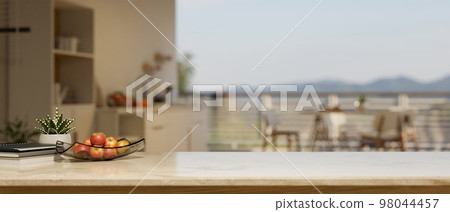 Copy space on marble kitchen tabletop with apple tray and decor over blurred kitchen with dining table 98044457