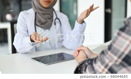 cropped image, A professional Asian Muslim female doctor talking with a patient in the office 98044685