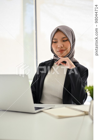 Attractive Asian Muslim businesswoman hand on chin, thinking and planning new strategy Attractive Asian Muslim businesswoman hand on chin, thinking and planning new strategy 98044714