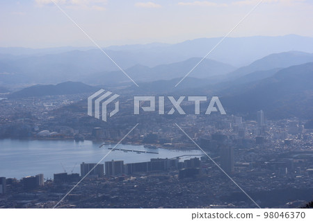 琵琶湖風景與港口和市區的城市景觀與朦朧的藍天、山脈、建築物等。 琵琶湖風景與港口和市區的城市景觀與朦朧的藍天、山脈、建築物等。 98046370