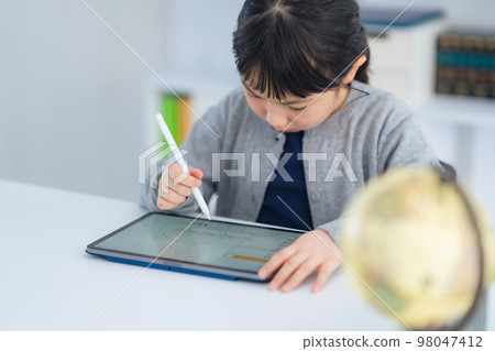 Girl studying on a tablet 98047412