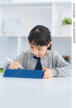 Girl studying on a tablet Girl studying on a tablet 98047414