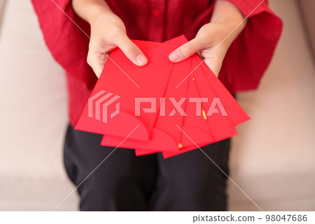 Woman holding Chinese red envelope, money gift for happy Lunar New Year holiday Woman holding Chinese red envelope, money gift for happy Lunar New Year holiday 98047686