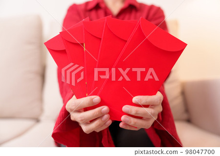 Woman holding Chinese red envelope, money gift for happy Lunar New Year holiday Woman holding Chinese red envelope, money gift for happy Lunar New Year holiday 98047700