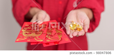 Woman holding Chinese red envelope with gold bullion, money gift for happy Lunar New Year holiday. Chinese sentence means happiness, healthy, Lucky and Wealthy 98047806