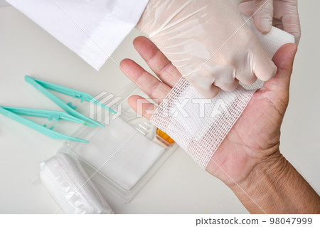 Doctor doing wound dressing care and bandaging patient's hand, Hand surgery treatment Doctor doing wound dressing care and bandaging patient's hand, Hand surgery treatment 98047999