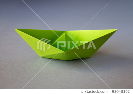 Green paper boat origami isolated on a grey background 98048302