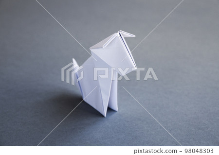 White paper dog origami isolated on a grey background White paper dog origami isolated on a grey background 98048303