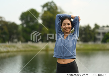 Portrait of sportswoman stretching before running in the park. Fitness, sport and healthy lifestyle concept 98048613