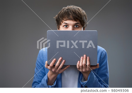 young man hiding his face with laptop 98049306