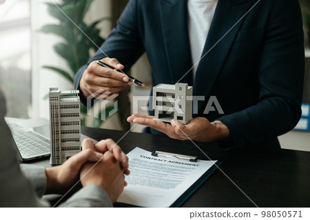Signing a contract. Client and broker agent, lease agreement, successful deal and Young business sitting at the desk . Signing a contract. Client and broker agent, lease agreement, successful deal and Young business sitting at the desk . 98050571