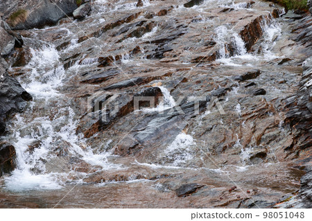 Beautiful texture of black-brown granite, saturated with various shades of minerals included in it Beautiful texture of black-brown granite, saturated with various shades of minerals included in it 98051048