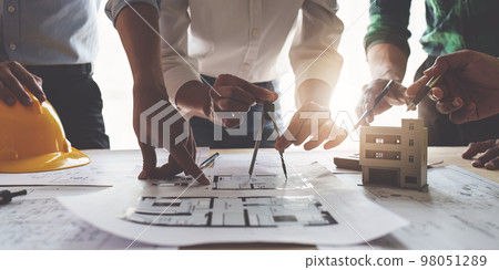 Architect team working with blueprints for architectural plan, engineer sketching a construction project, green energy concept 98051289