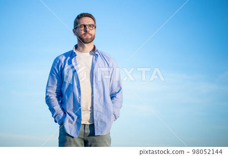 pensive caucasian man standing peaceful. pensive man on sky background with copy space. pensive caucasian man standing peaceful. pensive man on sky background with copy space. 98052144