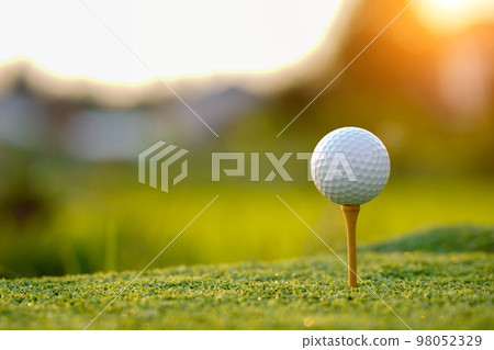 Golf ball on tee in the evening golf course with sunshine background 98052329