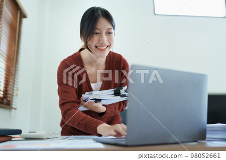 financial, Planning, Marketing and Accounting, portrait of Asian employee checking financial statements using documents and computer at work.. 98052661