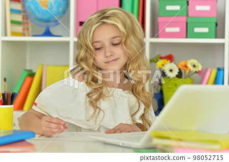 girl using laptop at desk at home 98052715
