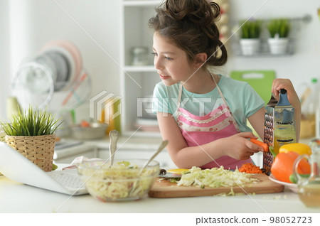 Beautiful girl preparing a salad in the kitchen 98052723