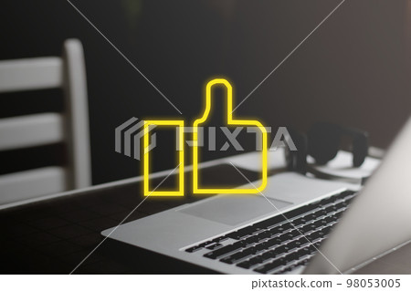 Yellow like icon on minimal workplace background. Social media approval concept 98053005