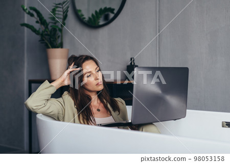 Woman secluded at home in the bathroom and works 98053158