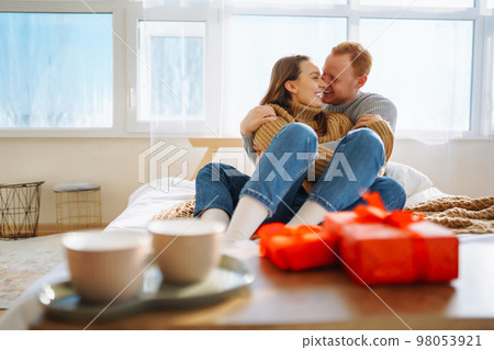 Couple in love relaxing at home on bed while they hug each other. Valentine's Day, holiday concept. 98053921